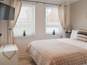 a bedroom with a bed and two windows at Bell Tower B in Berwick-Upon-Tweed