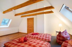 two beds in a attic room with wooden beams at Haus am See - zur roten Tür in Templin