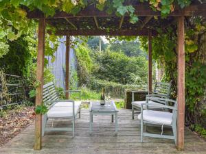 a gazebo with two chairs and a table with a bottle of wine at Yr Ysgubor - U45300 in Carmarthen +2 photos