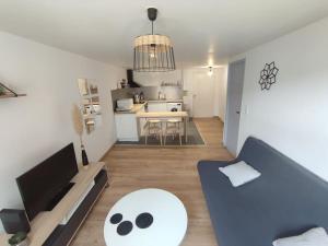 a living room with a blue couch and a kitchen at Appartement T2 centre de Lourdes in Lourdes