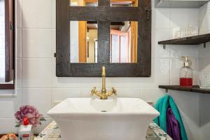 a bathroom with a white sink and a mirror at La Casina Del Fresnu in Onón +23 photos