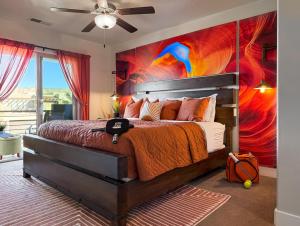 a bedroom with a bed with a painting on the wall at Stargazer – Luxury Condo, Rooftop Views, Private Hot Tub in St. George