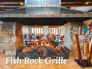 a fire pit in a restaurant with the words inn fish rock grill at Stargazer – Luxury Condo, Rooftop Views, Private Hot Tub in St. George
