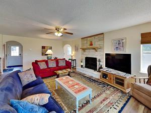 a living room with a red couch and a fireplace at Tanglewood in Ruidoso