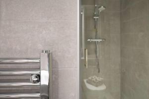 a shower with a glass door in a bathroom at Practical Studio For 2 In Leeds with Free Grab&Go Breakfast in Headingley