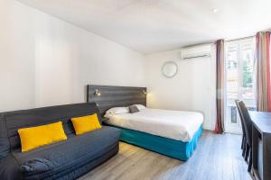 un dormitorio con una cama y un sofá en Hotel de la Baie, en Bandol