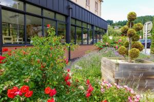 a garden of flowers in front of a building at Hotel Restaurant de la Poste in Saint-Just-en-Chevalet