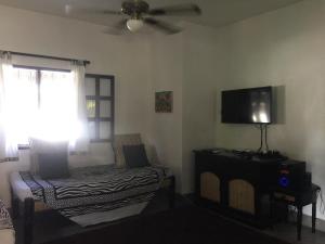 ein Wohnzimmer mit Bett und Flachbildfernseher in der Unterkunft Hibiscus in Mambrui in Mambrui