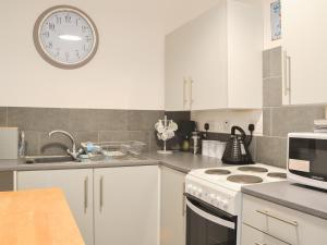 a kitchen with a stove and a clock on the wall at Apartment 1 - Uk44165 in Bridlington