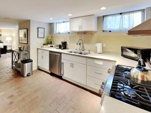 a kitchen with white cabinets and a sink and a stove at Casa en Canyon in Santa Fe