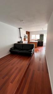 a living room with a black couch on a wooden floor at Casa Mellow in Ghent