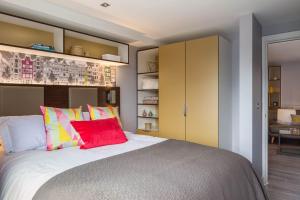 a bedroom with a large bed with colorful pillows at Comfortable Studio For 2 In Leeds with Free Grab&Go Breakfast in Headingley