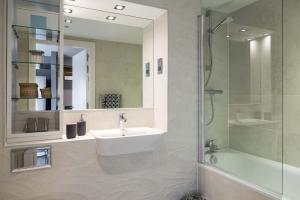 a bathroom with a sink and a shower and a mirror at Comfortable Studio For 2 In Leeds with Free Grab&Go Breakfast in Headingley