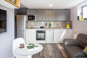 a kitchen and living room with a couch and a table at Comfortable Studio For 2 In Leeds with Free Grab&Go Breakfast in Headingley