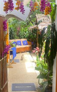 a patio with a couch and a cat in a garden at EXCLUSIVE VILLA, four or five bedrooms in Karon Beach