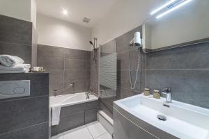 a bathroom with a sink and a tub and a shower at Hotel de la Baie in Bandol +17 photos