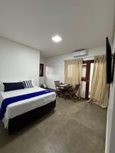 ein Schlafzimmer mit einem Bett und einem Fernseher in der Unterkunft Casa vista mar a 20 metros da praia de garça torta em Maceio in Maceió
