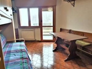 Habitación con mesa de madera y cama en La Piramide sulle piste, en Prato Nevoso 5 fotos más