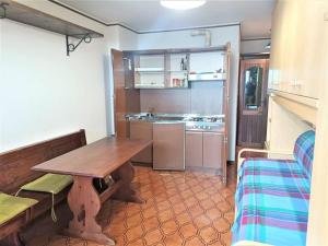 a kitchen with a wooden table in a room at La Piramide sulle piste in Prato Nevoso