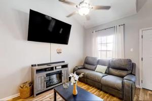 a living room with a couch and a flat screen tv at Playstay Houston in Houston