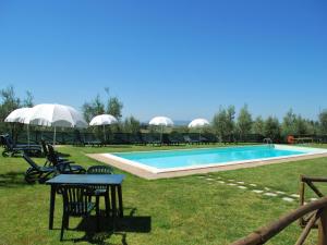 una piscina con sillas y una mesa en el césped en Rustic style flat with swimming pool, en Guistrigona