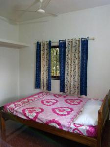 een bed in een kamer met een raam bij Nhanji House in Arambol