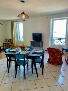 a dining room with a table and chairs and a television at La Langouste ROUGE in Camaret-sur-Mer +42 photos