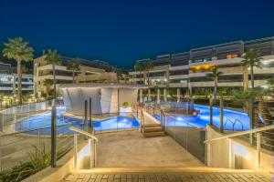 a building with a swimming pool at night at Azure Libra Apartment Flamenca Village in Orihuela Costa