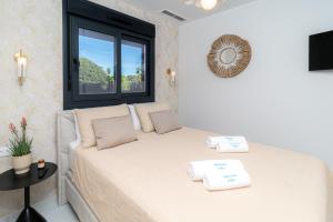 two beds in a room with a window at Azure Libra Apartment Flamenca Village in Orihuela Costa +12 photos