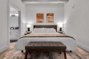 a bedroom with a large bed with two paintings on the wall at Industrial Loft Living 2BR 2BA in Greenville