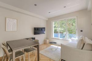 Saint-Didier-au-Mont-dʼOrT2 moderne pour 4 - St-Didier-au-Mont-d'Or的带桌子和椅子的白色客厅