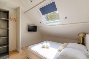 Saint-Didier-au-Mont-dʼOrT2 moderne pour 4 - St-Didier-au-Mont-d'Or的阁楼卧室设有床和窗户。