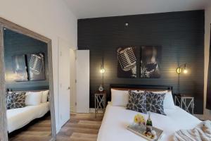 a bedroom with two white beds and a black wall at Great Location 1 Bedroom Sleeps 4 in Nashville