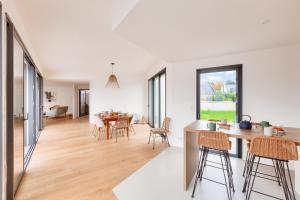 a kitchen and living room with a table and chairs at 800m de la plage, maison neuve pour 10, piscine in Pléneuf-Val-André +18 photos