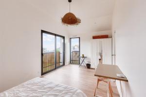 a bedroom with white walls and a bed and a table at 800m de la plage, maison neuve pour 10, piscine in Pléneuf-Val-André