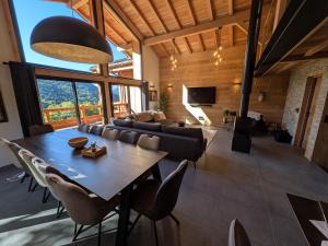 a living room with a table and a couch at Sophisticated, Relaxed Chic - Chalet Sika rented Sunday-Sunday in Vaujany