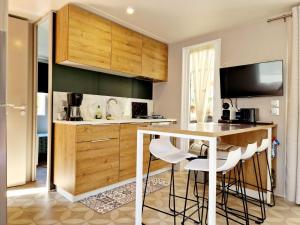 eine Küche mit einer Theke und einem Tisch mit Stühlen in der Unterkunft Camping Del Mar 52, Mobile Home Excellence, 3 chambres, 6 personnes, bord de mer in Argelès-sur-Mer