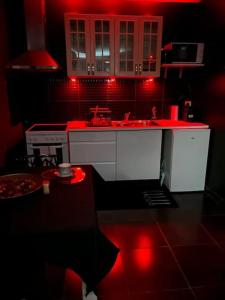 a kitchen with red lighting in a dark room at Love-cocon sur mantes sur mante in Mantes-la-Jolie +2 photos