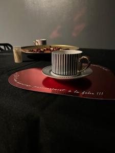 a coffee cup on a red plate on a table at Love-cocon sur mantes sur mante in Mantes-la-Jolie