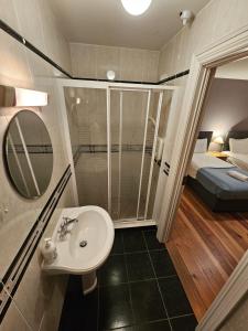 a bathroom with a sink and a shower and a bed at 8 Clos Na Feirme Three Bedroom House with Hot Tub in Galway
