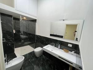 a bathroom with a sink and a toilet and a mirror at Suite Indipendenza Perugia in Perugia