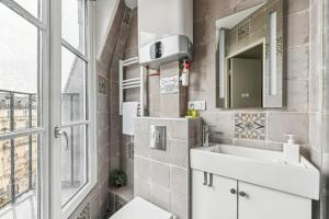 a bathroom with a sink and a mirror and a window at Studio Mac Mahon - Champs Elysees in Paris