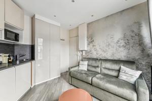 a living room with a couch and a kitchen at Studio Mac Mahon - Champs Elysees in Paris