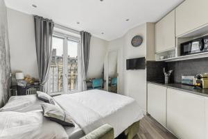 a bedroom with a large bed and a kitchen at Studio Mac Mahon - Champs Elysees in Paris