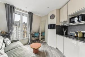 a living room with a couch and a kitchen at Studio Mac Mahon - Champs Elysees in Paris