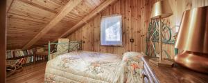 a bedroom with a bed in a wooden cabin at 5' Bus to the Ski Slopes, Panoramic Chalet in Champoluc