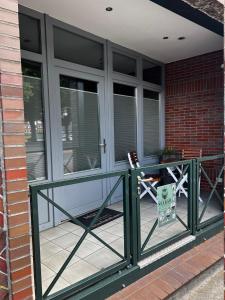 porche delantero con barandilla verde y ventanas en Ferienwohnung Seebär, en Emden
