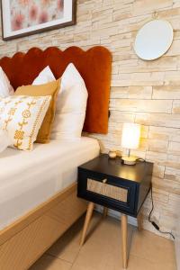 een bed met een houten hoofdeinde en een tafel met een lamp bij Würzburg Studio mit Dachterrasse - Tiefgarage & Nähe Bahnhof in Würzburg