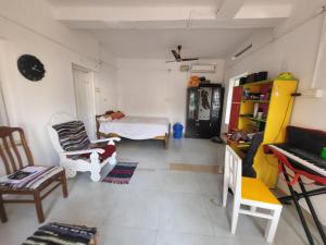 a living room with a bed and a table and chairs at Emma Homestay in Pattiyūrgrāmam