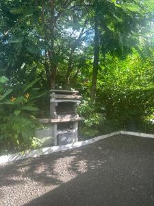 a stone pillar in the middle of a garden at Villa Ti Gîte - Piscine privée in Le Marin
